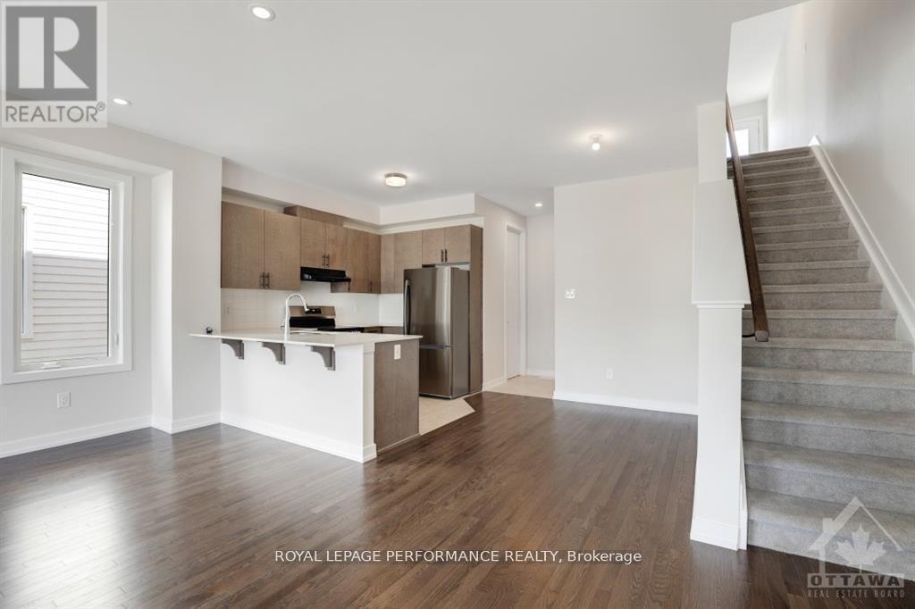 A spacious, empty room with a staircase on the right side.