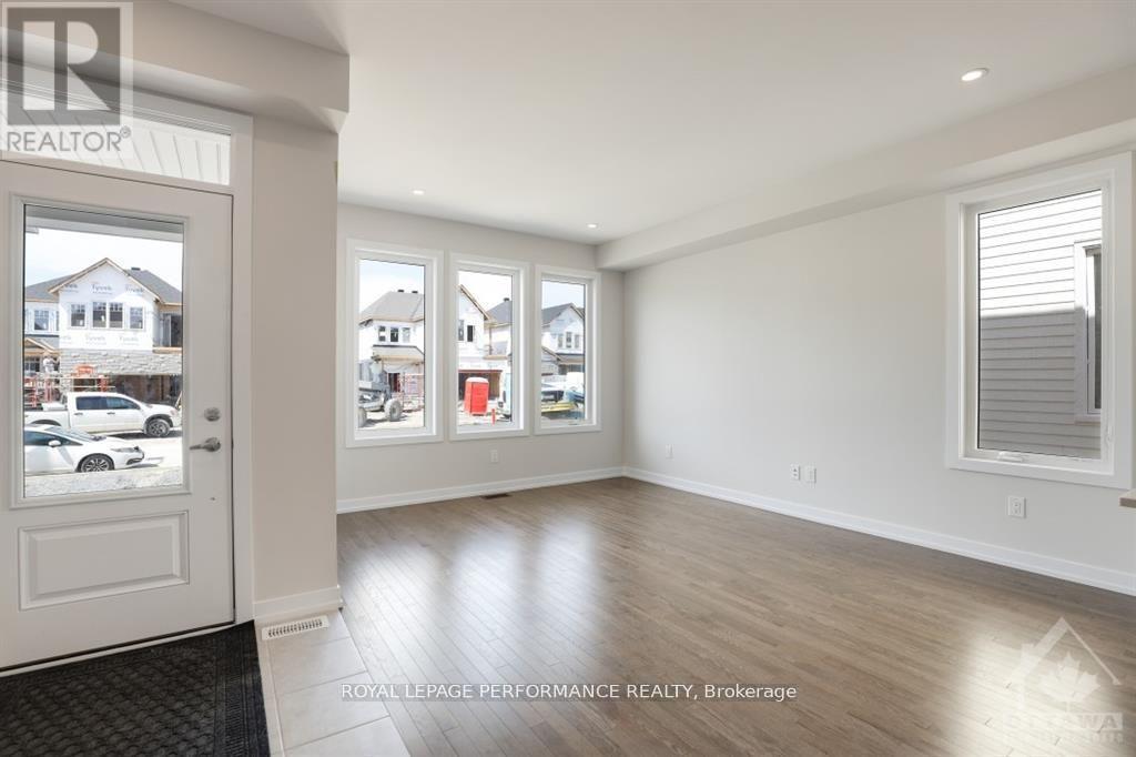 A room with a white door and windows showing other houses.