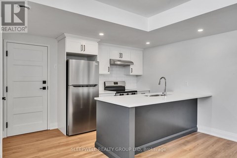 A modern kitchen with a stainless steel refrigerator and a white countertop.