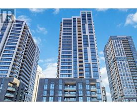 A cityscape with tall buildings and a clear blue sky.