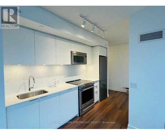 A modern kitchen with white cabinets and stainless steel appliances.
