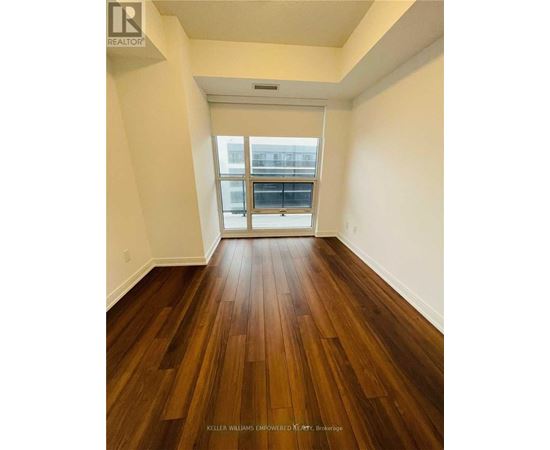 A room with a wood floor and a window.