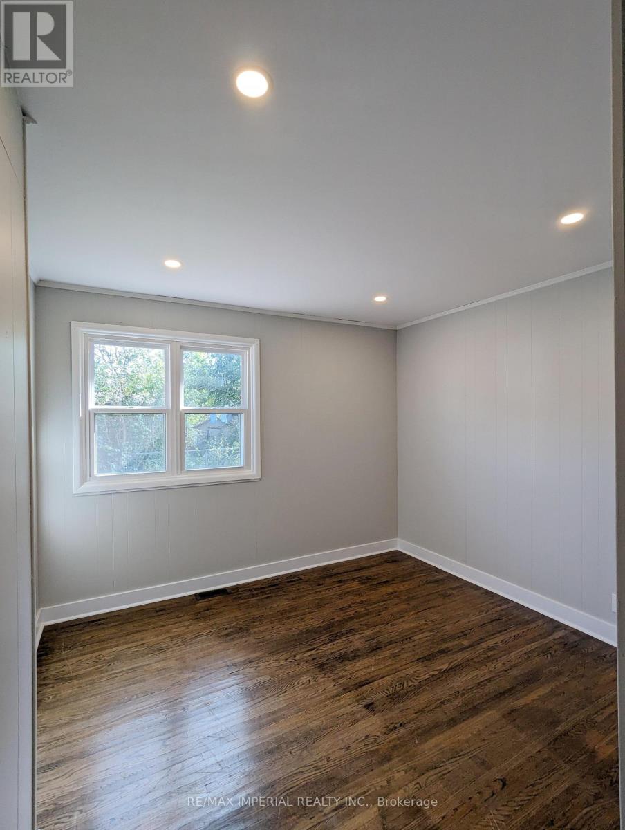 A room with a window and wooden flooring.