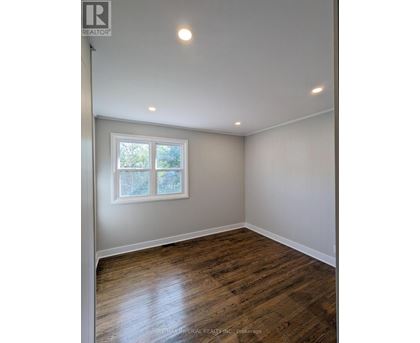 A room with a window and wooden flooring.