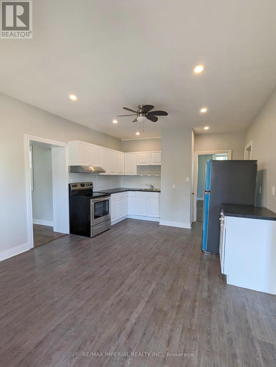 A kitchen with white cabinets and a black fridge.