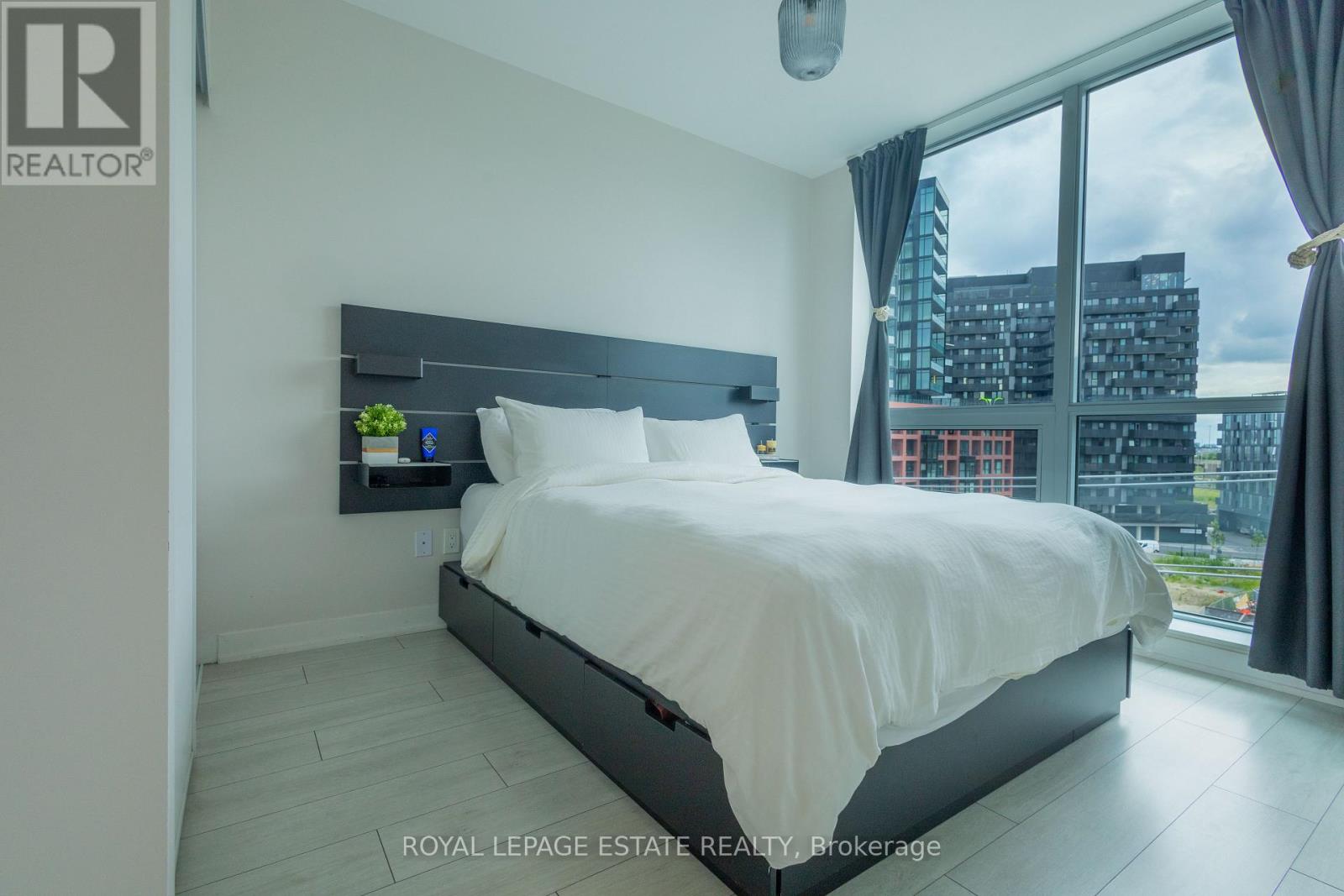 A bedroom with a large bed and a view of the city.