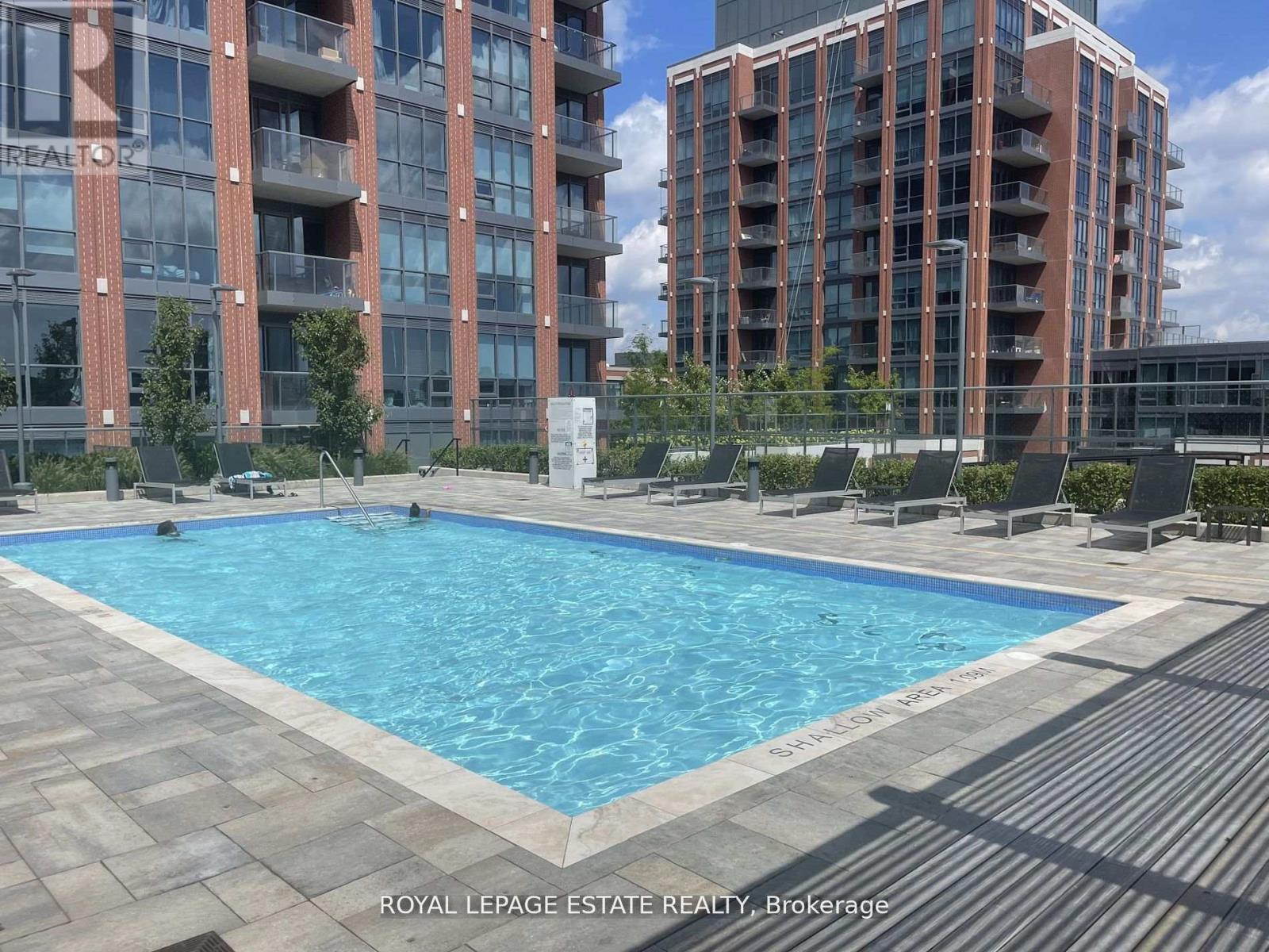 A swimming pool in front of a building with the words "Royal LePage Estate Realty Brokerage" written on it.
