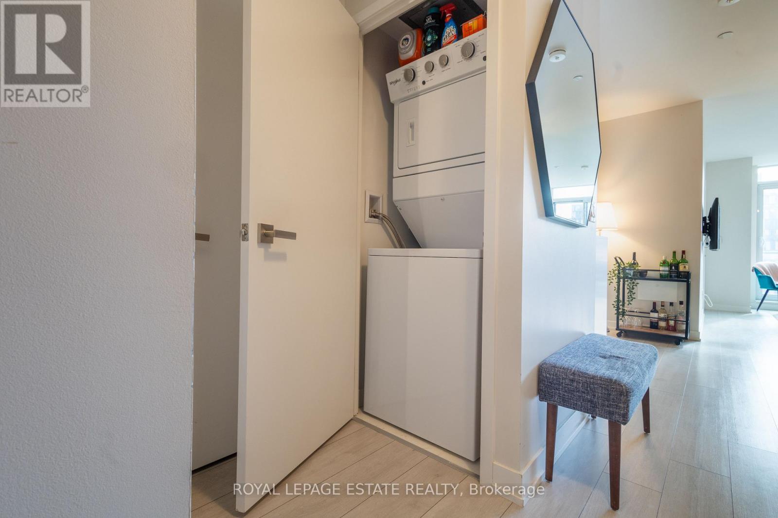 A small kitchen with a white oven and a blue stool.