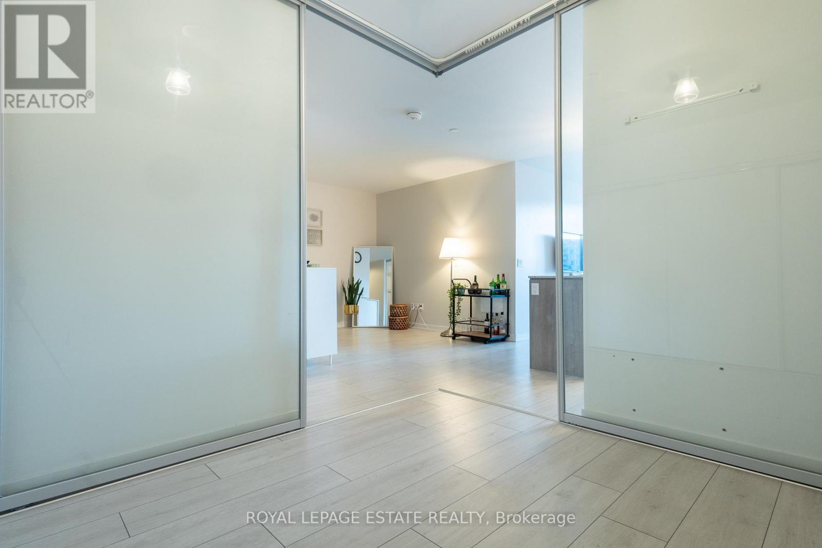 A spacious room with a glass door leading to another room.