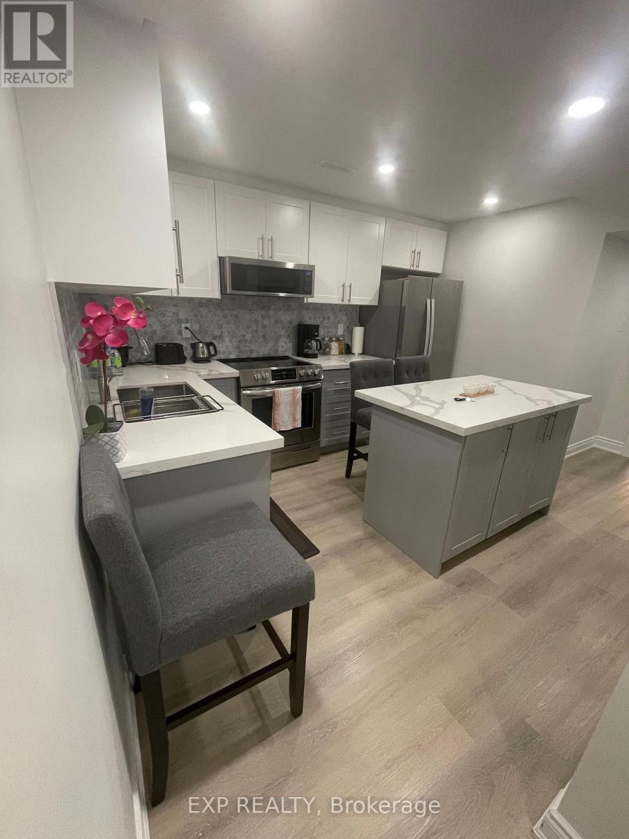 A kitchen with a grey chair and a white counter.