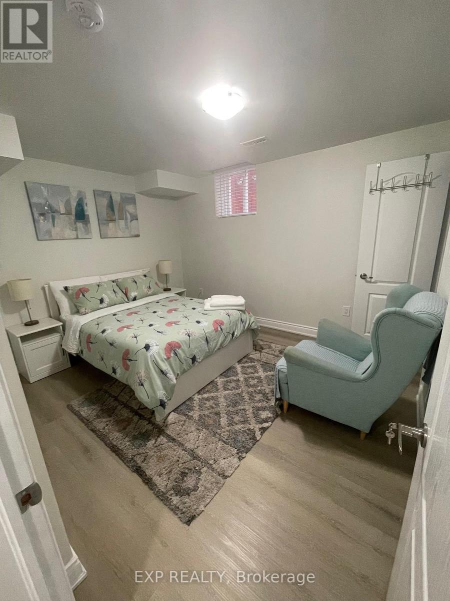 A bedroom with a bed, chair, and pictures on the wall.