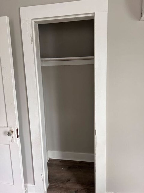 A white door is open to a room with a grey wall.