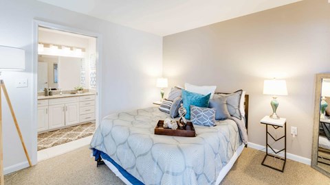 A bedroom with a large bed and a mirror on the wall.