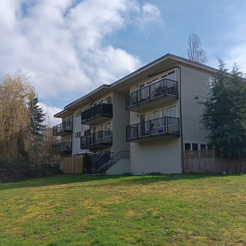 A two-story apartment building with a balcony on the second floor.