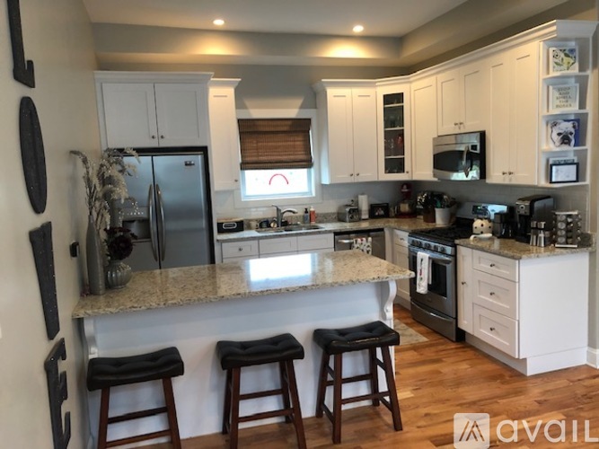 A kitchen with white cabinets and a granite countertop.