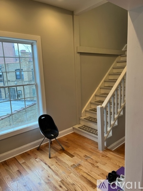 A chair is in front of a window with a view of a building outside.