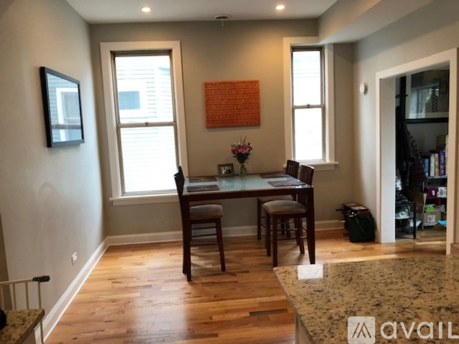 A dining room with a table and chairs.
