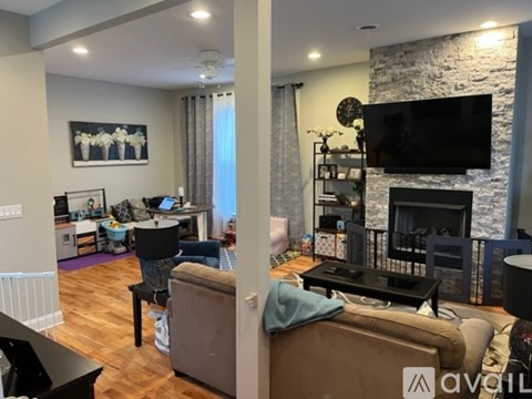 A living room with a fireplace and a television on the wall.