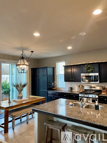 A kitchen with black cabinets and granite countertops.