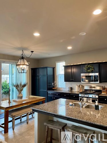 A kitchen with black cabinets and granite countertops.