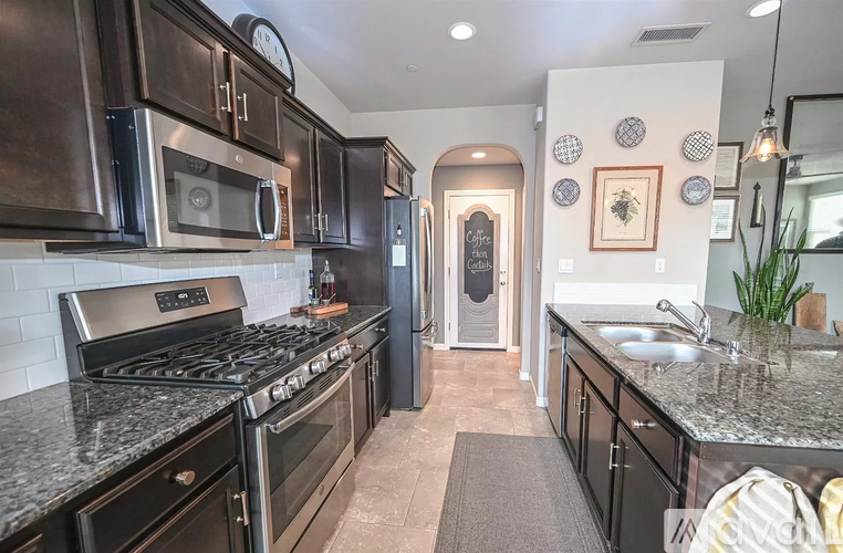 A kitchen with black cabinets and a granite countertop.