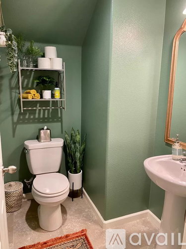 A bathroom with green walls and a white toilet.