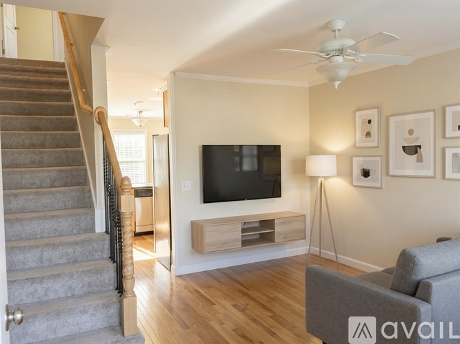 A living room with a staircase and a television.