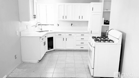 A white kitchen with a stove and sink.