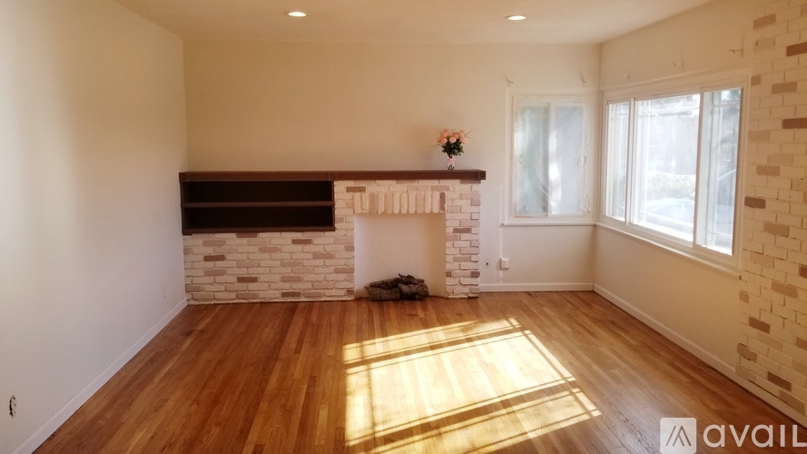 A room with a fireplace and wooden floors.