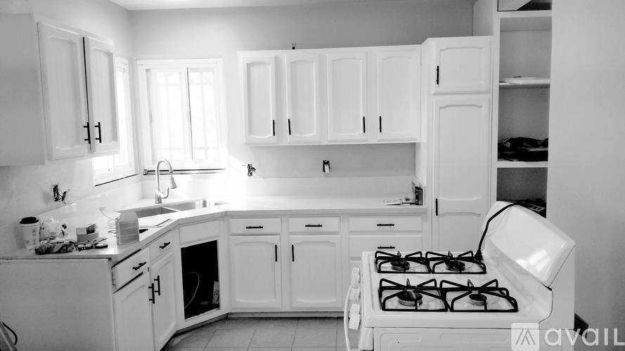 A black and white photo of a kitchen with a stove and cabinets.
