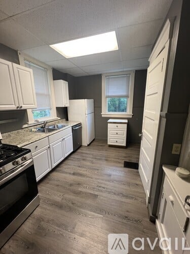 A kitchen with white cabinets and a black stove top oven.