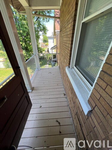 A wooden deck with a white railing and a window.