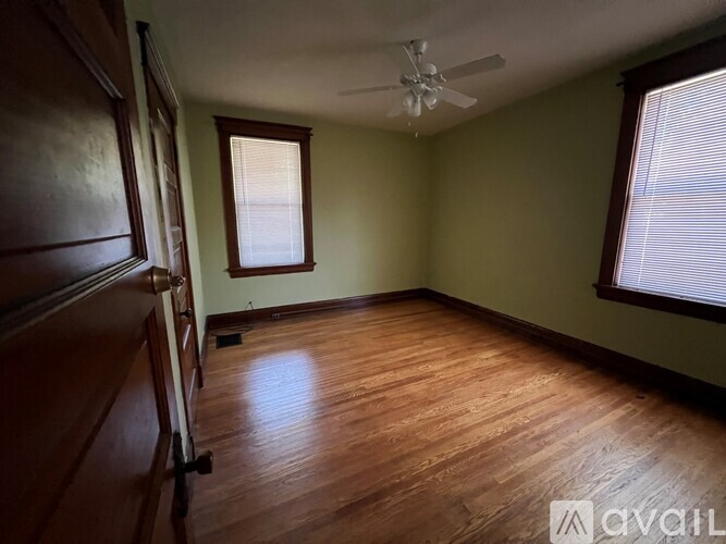 A room with a wooden floor and a ceiling fan.