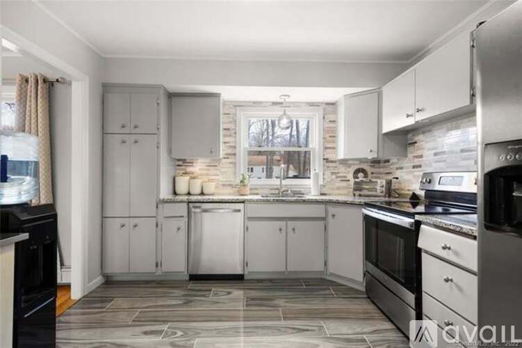 A kitchen with a black oven and a stone floor.