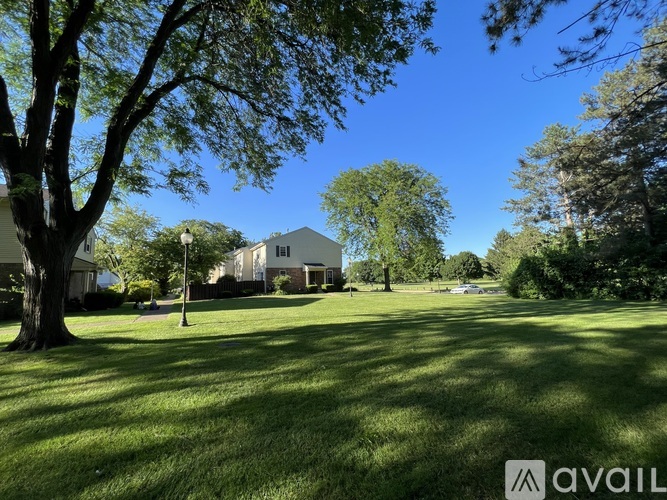 A house is situated in a grassy area with trees around it.