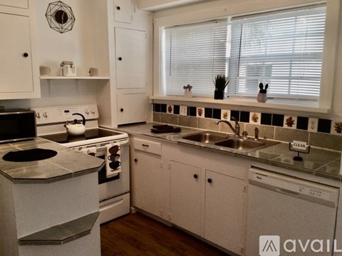 A kitchen with white cabinets and a black stove top.