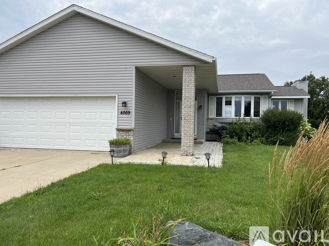 A house with a garage and a driveway in front.