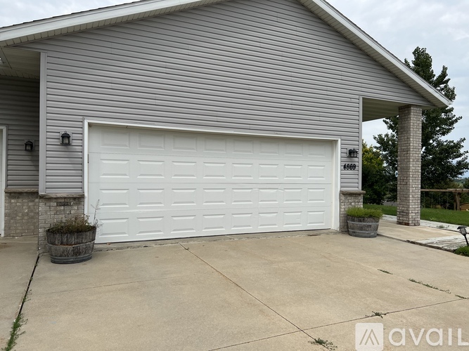 A house with a white garage door and a grey roof.