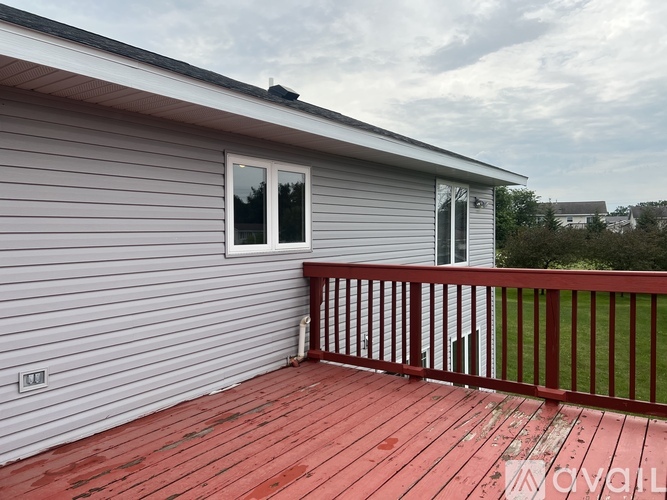A house with a red deck and a grey exterior.