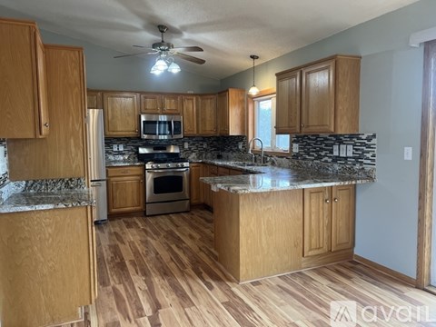 A kitchen with wooden cabinets and a granite countertop.