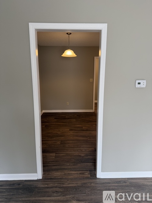 A room with a wooden floor and a light hanging from the ceiling.