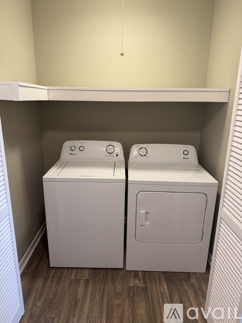 Two white washing machines in a small laundry room.