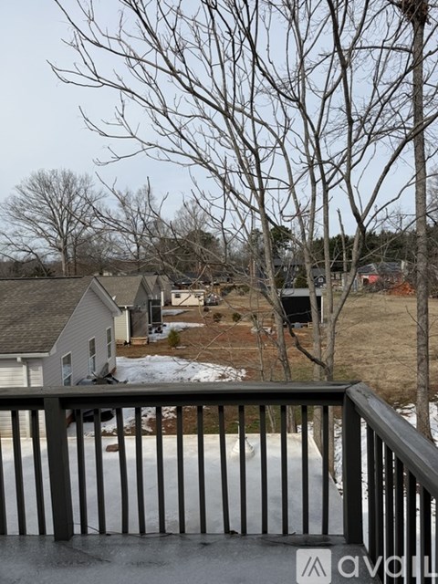 A view from a balcony overlooking a snowy landscape with bare trees and houses.