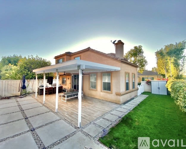 A house with a patio and a white pergola is for sale.