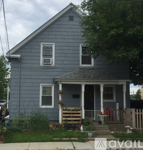 A blue house with a porch and a white door.
