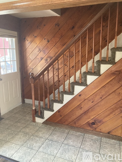A wooden staircase with a carpeted runner.