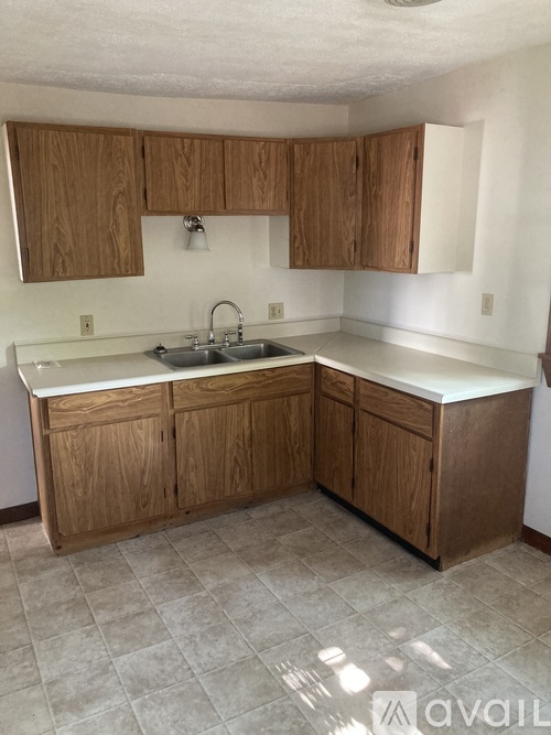 A kitchen with wooden cabinets and a white countertop.