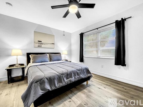 A bedroom with a large bed and a ceiling fan.