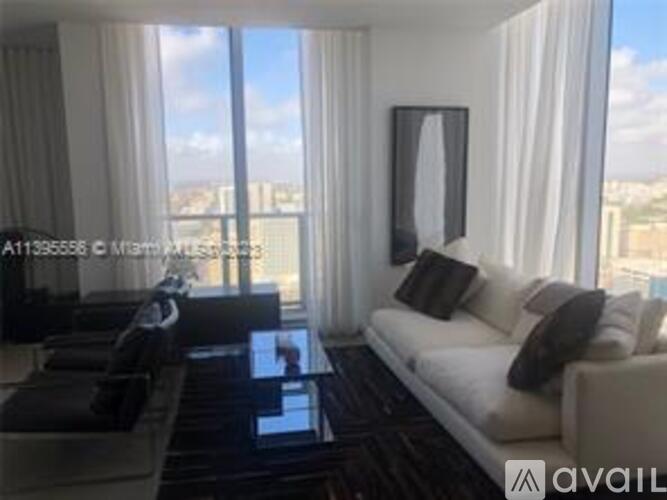 A modern living room with a large window overlooking the city.