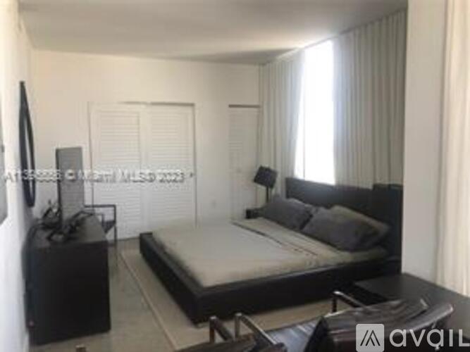 A bedroom with a bed, nightstand, and a television.